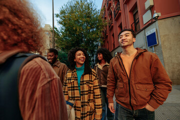 Group of young students walking and talking together in the city