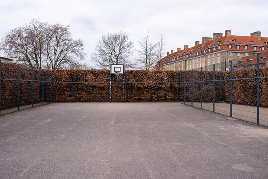 Empty outdoor sports court with urban background, representing recreation, community life, and minimalist perspectives of contemporary design and architecture in public environments.