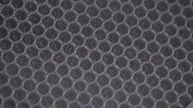 A macro shot of a new activated carbon filter for an air purifier. The honeycomb structure is filled with carbon pellets designed to absorb odors, gases, and volatile organic compounds (VOCs).