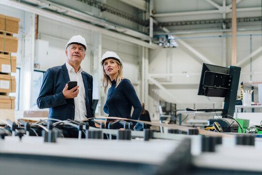 Business colleagues looking up and discussing in carpentry factory
