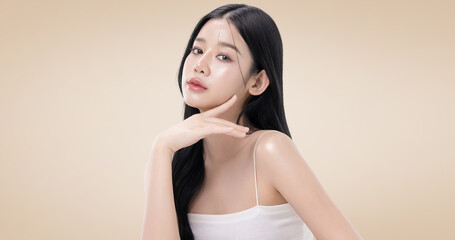 Fototapeta premium Close up perfect beauty face of young beautiful Asian woman posing gracefully with a soft smile isolated on brown background. Facial and skin care concept for commercial advertising.