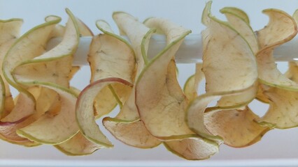 geschnittene Apfelscheiben auf Stange aufgereiht zum Trocknen als Dörrobst