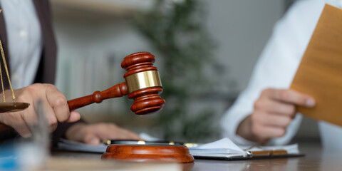 Legal Representation. Gavel and contract documents on a lawyer's desk during a consultation.