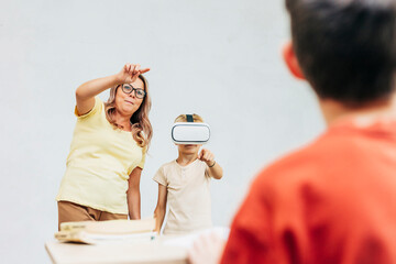 Teacher guiding student with VR headset in modern classroom