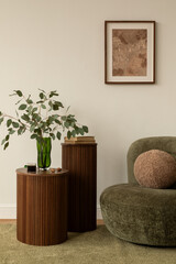 Modern living room with green armchair, round cushion, mock up poster and wooden side tables decorated with books, coffee, and a glass vase with eucalyptus. © FollowTheFlow