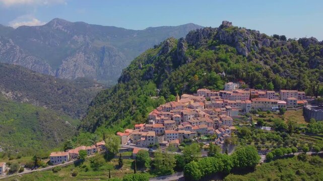 An aerial drone shot captures the picturesque medieval village of Sainte Agnes, nestled high in the Alpes-Maritimes mountains of the French Riviera.