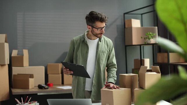 A man wearing glasses is looking at a clipboard with a box on it