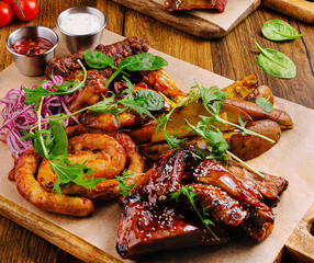 Delicious grilled meat platter with sides served on wooden table