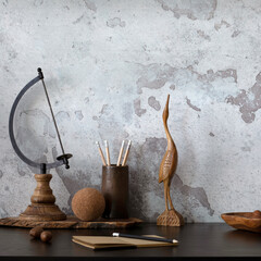 Creative composition of home office interior with black desk, gray concrete wall, pencil holder,  books, glasses and office accessories. Home decor. Template.