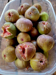 Succulent figs in a plastic container, whispering tales of Mediterranean harvest festivals and mystical Fig Newton Day celebrations