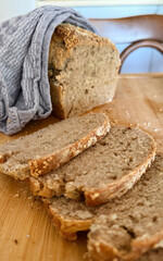 Rustic wholegrain bread sliced under cozy knit, evoking Lammas harvest vibes, artisan baking solace, Celtic traditions whisper