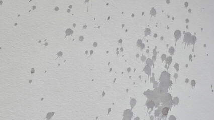 Splattered gray paint forms an abstract constellation on barren drywall, evoking urban mystery and minimalist serenity, apt for International Art Day