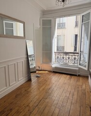 Sunlight kisses rustic wooden floors in a Parisian apartment, evoking Bastille Day charm and serene urban meditation