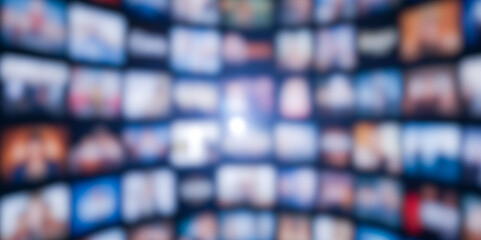 Abstract background of blurred video wall for streaming service, infinite media library on demand, futuristic entertainment technology concept with blue light glow.
