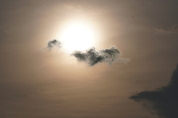 Sun Hidden Behind Dark Cloud in Dramatic Sky