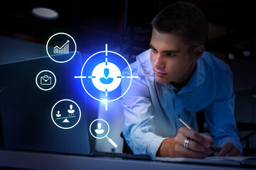 Young professional analyzes data on laptop while focusing on task in modern workspace