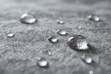 Waterproof vinyl planks flooring concept. Close-up of water droplets on a textured surface in grayscale.