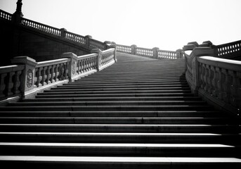 Obraz premium Monumental staircase ascending towards bright light in monochrome design