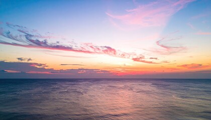 Fototapeta premium Serene Sunrise Over Open Ocean with Soft Pink And Orange Sky