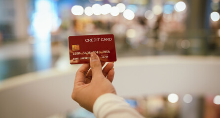 A woman holds a credit card in her hand, symbolizing payment, shopping, finance, banking,...