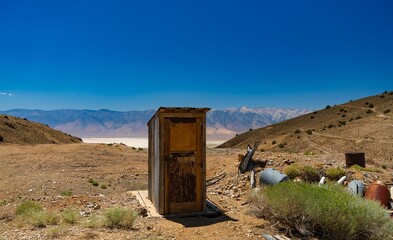 Rustic Outhouse in Desert Landscape