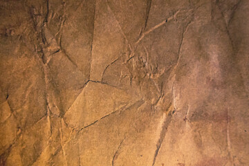 Crumpled brown paper texture with visible folds.