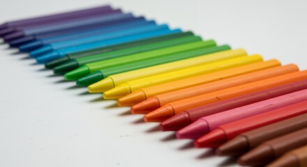 Naklejka premium Vibrant Rainbow Crayons Lined Up on White Surface