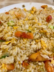 Close-up of freshly cooked fried rice with vegetables, egg, and shrimp, showcasing vibrant colors and delicious Asian cuisine.