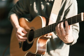 Fototapeta premium Young man playing guitar during musical performance