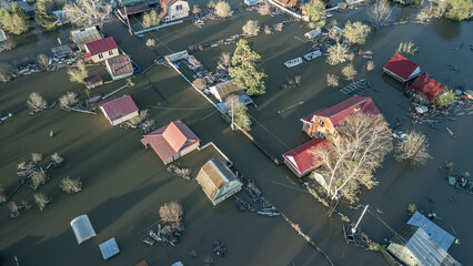 Aerial drone footage showing severe flooding with submerged houses and roads. Wide overhead view of a disaster zone after heavy rainfall, showcasing water damage, extreme weather, and climate-related 