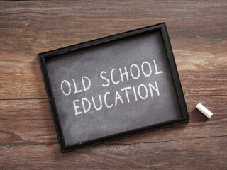 Old School Education Written on Small Blackboard with Piece of White Chalk