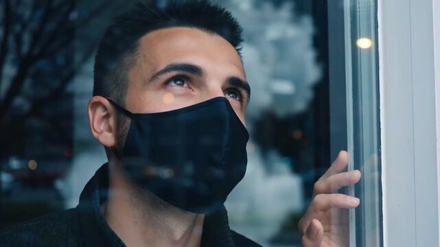 Jeune homme pensif portant un masque &agrave; l'int&eacute;rieur.