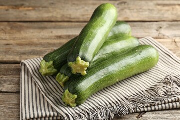 Fresh ripe zucchinis on wooden table, closeup