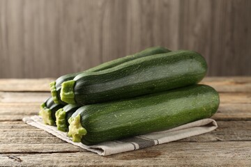 Fresh ripe zucchinis on wooden table, closeup
