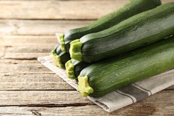 Fresh ripe zucchinis on wooden table, closeup. Space for text