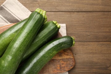Fresh ripe zucchinis on wooden table, top view. Space for text