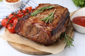 Delicious roast beef with rosemary, tomatoes and sauce on light table, closeup