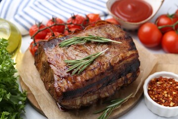 Delicious roast beef with rosemary, tomatoes and other products on table, closeup