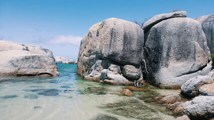 Giant boulders in the ocean with penguins © Gary