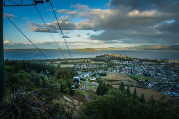 Skyline gondolas descend towards Rotorua city, overlooking Lake Rotorua and Mokoia Island under dramatic skies, capturing the perfect mix of adventure, nature, and breathtaking New Zealand scenery © Irina-B