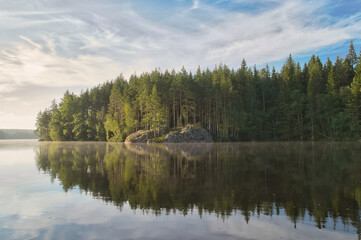 Fototapeta premium Sunset at the forest lake with reflection and rocks, peaceful natural scenery