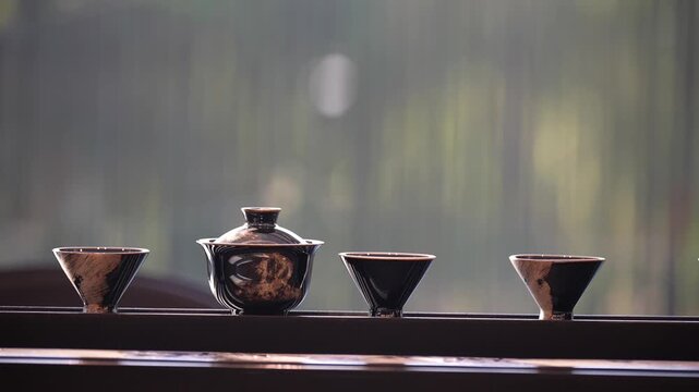 Traditional Chinese tea set with teapot and three cups placed quietly by a window in soft natural light