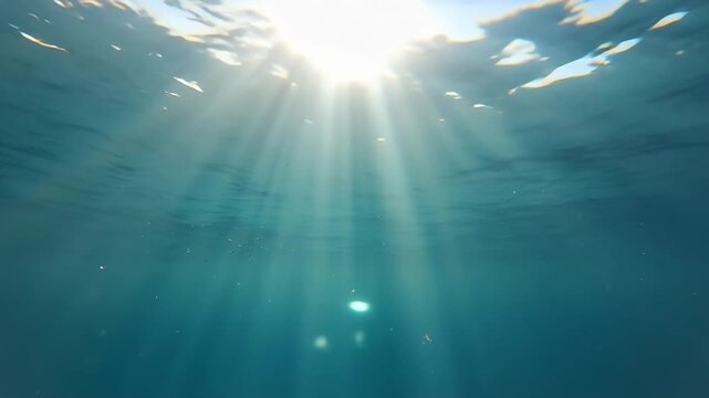 Bright beams of sunlight penetrating the ocean surface underwater.
