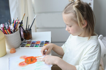 Healthy girl child painting with paintbrush indoor. Child 6 years old