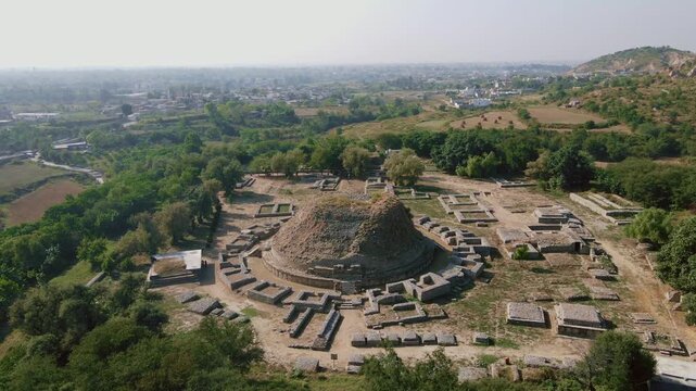 Aerial view of Dharmarajika Stupa, a captivating blend of ancient ruins and verdant trees, creating a striking contrast, Taxila, Punjab, Pakistan.