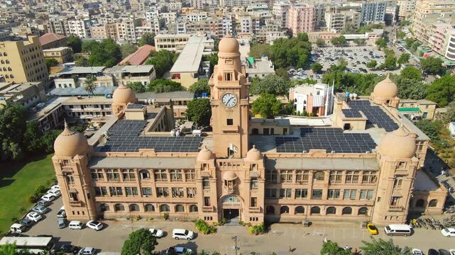 Aerial view of the historic KMC Building, with its sandstone facade contrasting against the modern solar panels on the roof, Karachi, Sindh, Pakistan.