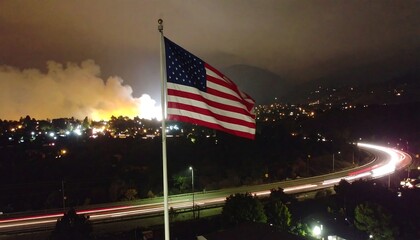 Nighttime view of a city, flag, and wildfire