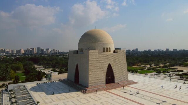 Aerial view of the Mazar-e-Quaid monument, a mausoleum with a large dome and geometric patterns, surrounded by lush green trees, Karachi, Sindh, Pakistan.