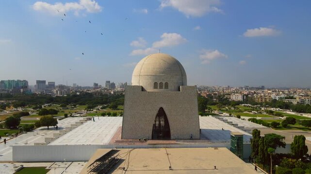 Aerial view of the Mazar-e-Quaid, a mausoleum with a large dome, set against a backdrop of the city skyline, Karachi, Sindh, Pakistan.