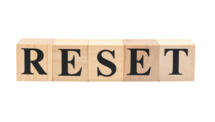 Wooden letter blocks arranged to spell the word RESET in bold black type.
